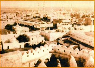 في الجانب الأيسر من الصورة تظهر المئذنة والقبة القديمة للمسجد.